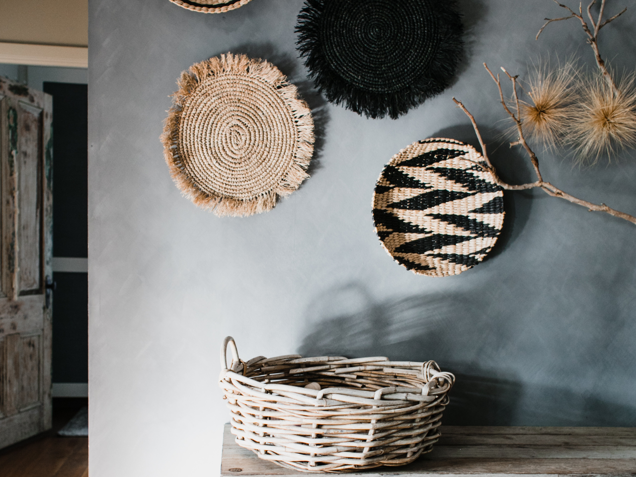 Artisan textured wall with natural woven baskets, highlighting the rise of texture and artisan finishes in 2025 Paint Trends