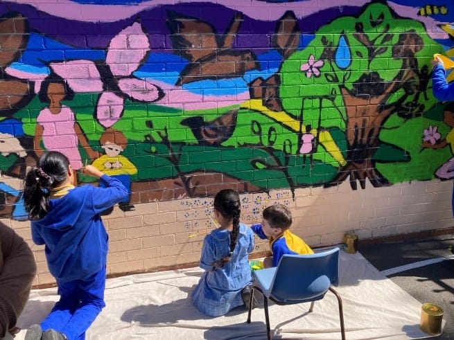 Students painting the Bexley Public School “Our Living Country” mural using Haymes Paint supplied through Network Render and Paint Tempe